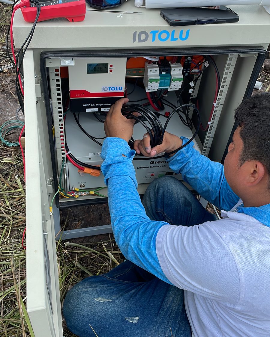 Technician connecting electronics in an IoF field station